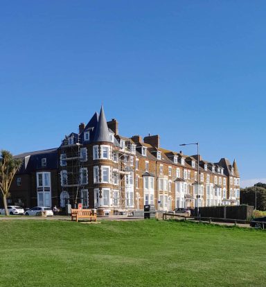 Victorian Building on top of grass hill.