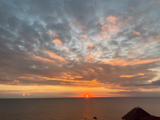 sunset in a cloudy sky, over the sea.